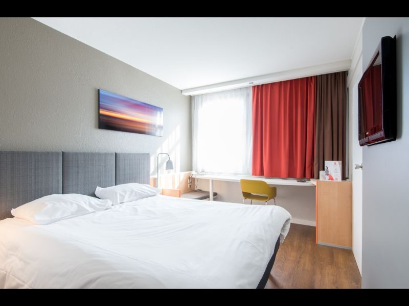 A hotel room with white sheets